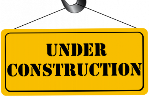 Under construction sign hanging from crane hook