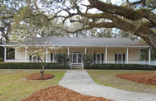 Exterior of restored yellow house next to grand oak with spanish moss